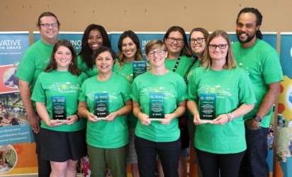 Picture of the 2018 ULIEA Winners posing in front of ULIEA banners at the 2018 Winners Summit in Northbrook, IL.